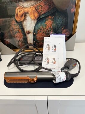 Dyson Airstrait Straightener. Bright nickel and rich copper colour.
